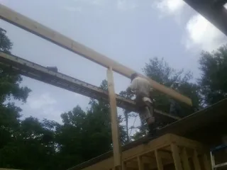 Carpenter setting a ridge beam over a new addition frame — Ice Dam Removal by Roofing Brothers in Chilo