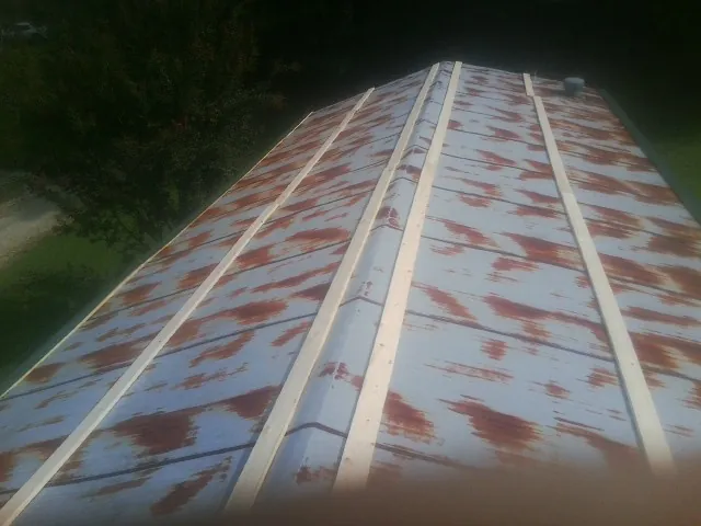 Rusted metal roof panels with new wood purlins before replacement — Storm Damage Roof Repair in Chilo by Roofing Brothers